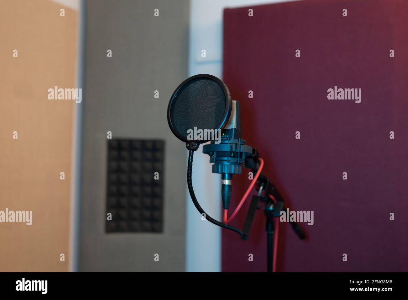 Filtro pop e microfono dinamico moderno con fili vuoti studio audio su sfondo sfocato Foto Stock