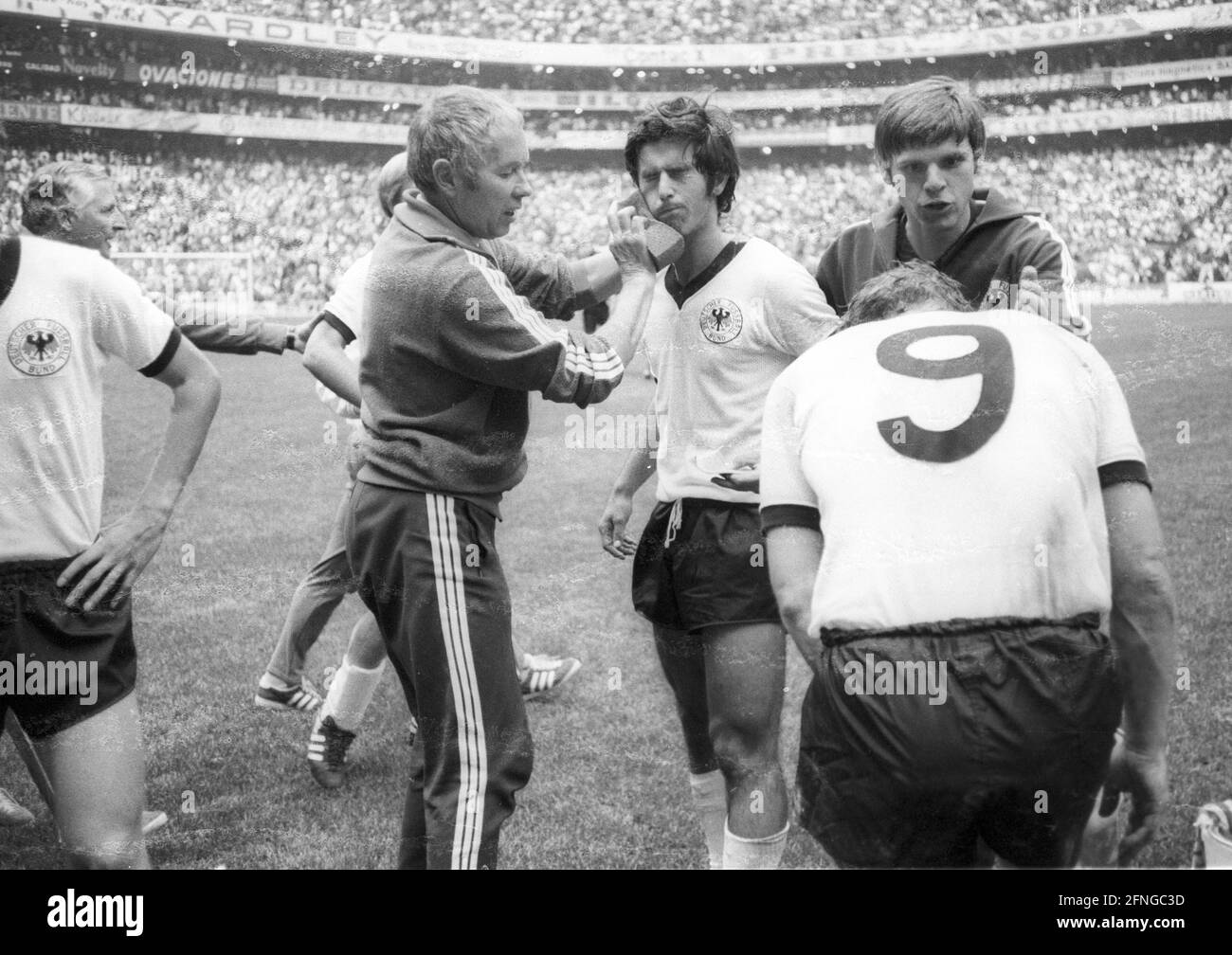 Coppa del mondo 1970: Germania - Italia 3:4 N.V. su 17.06.1970 a Città del Messico. Il team tedesco nella pausa di tempo extra. GERD Müller (centro) è trattato dal massaggiatore Erich Deuser. Destra: Wolfgang Weber parla con Uwe Seeler (9). All'estrema sinistra, meritato a metà: Coach Jupp Derwall. Nessuna versione del modello! [traduzione automatizzata] Foto Stock