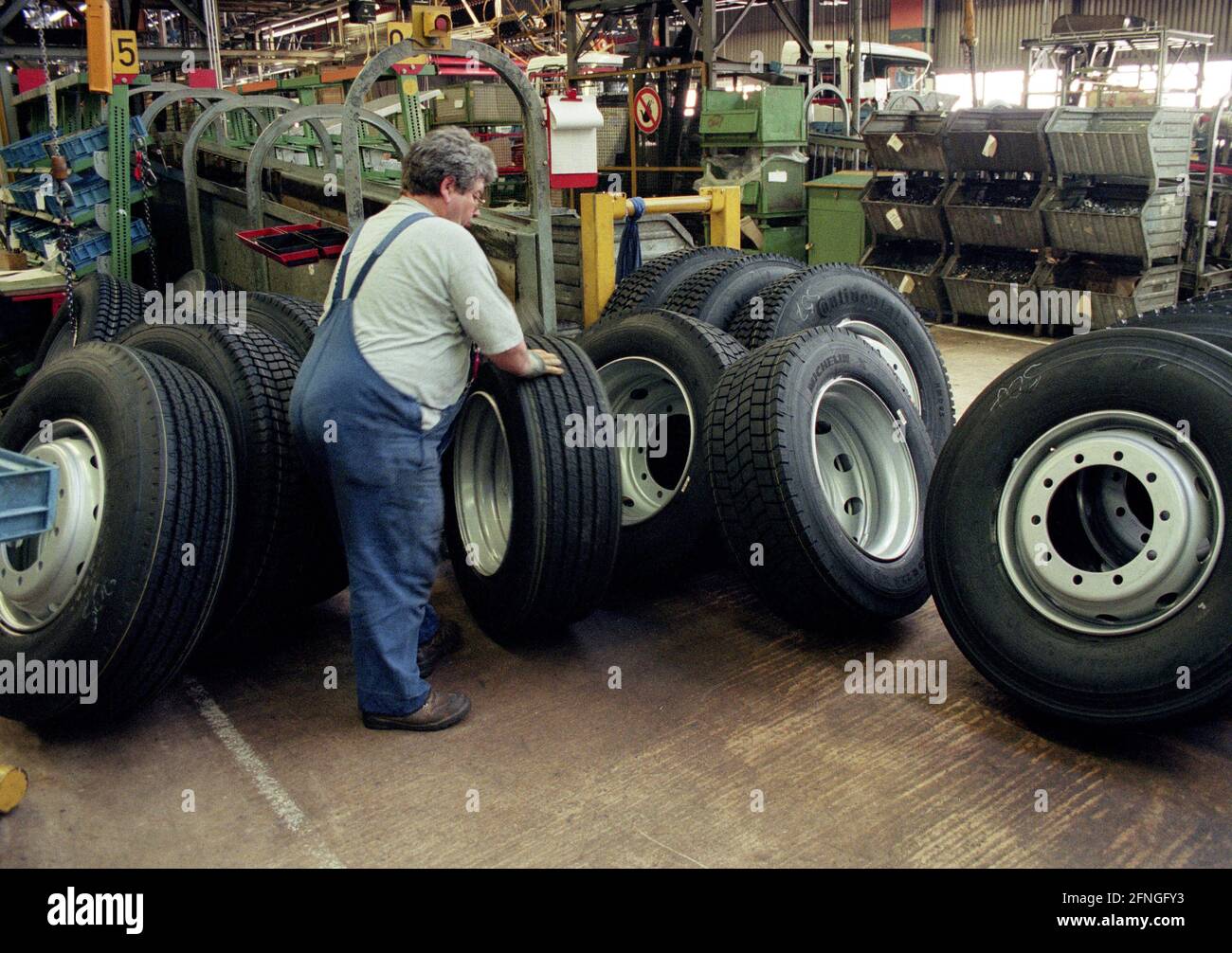 DEU , DEUTSCHLAND : produzione dei camion Mercedes-Benz ACTROS e ATEGO alla Daimler-Benz AG di Woerth : un lavoratore prepara le ruote , aprile 1998 [traduzione automatizzata] Foto Stock
