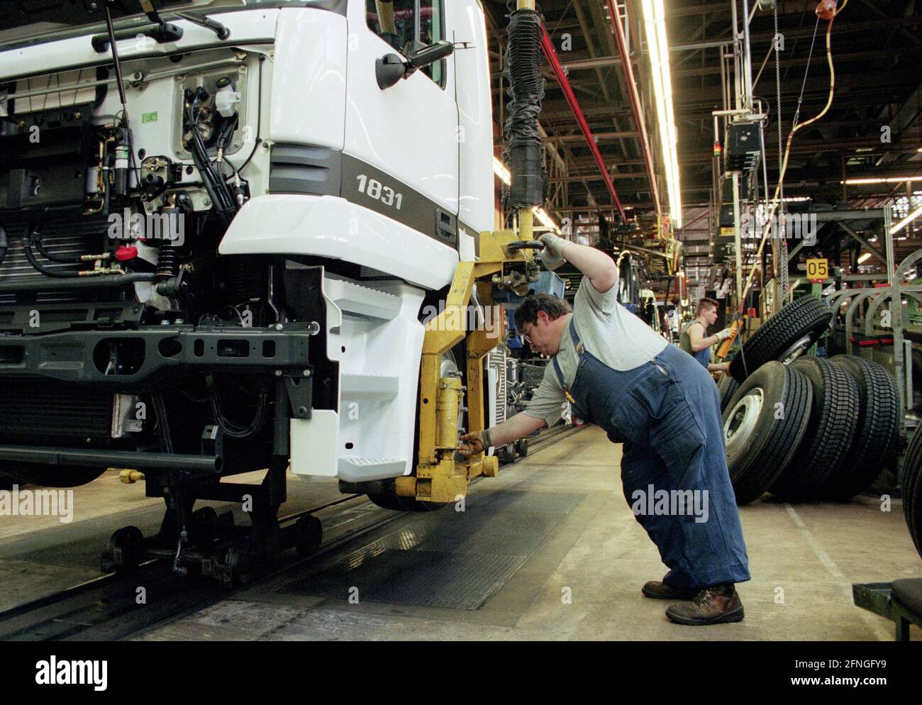 DEU , DEUTSCHLAND : produzione dei camion Mercedes-Benz ACTROS e ATEGO alla Daimler-Benz AG di Woerth : un lavoratore prepara il complessivo ruota , aprile 1998 [traduzione automatizzata] Foto Stock