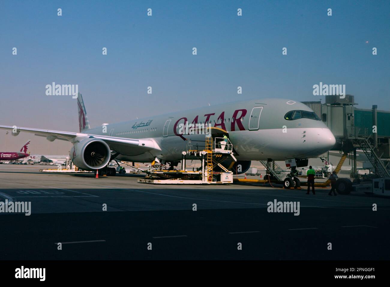 Doha, Qatar – 12 maggio 2021: L'aereo Qatar Airways viene caricato sul asfalto dell'aeroporto internazionale di Hamad Foto Stock