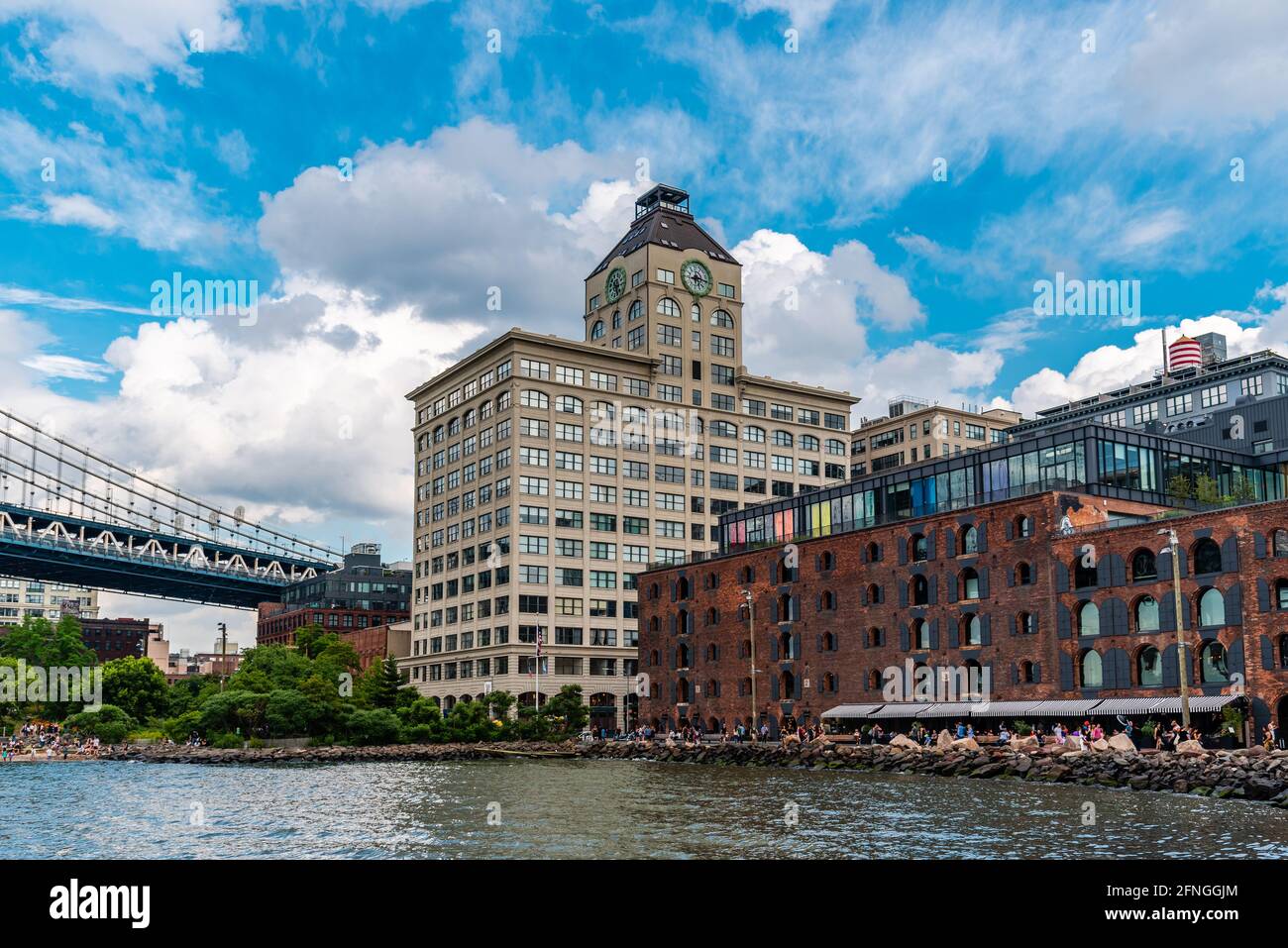 New York City, USA - 24 giugno 2018: Lungomare della zona DUMBO a Brooklyn. Giù sotto il cavalcavia del Manhattan Bridge. Vista contro il cielo blu durante Summe Foto Stock