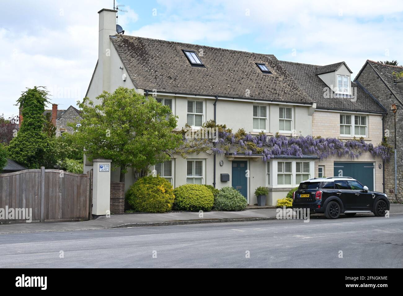 Una casa su Park Lane nel nord della città di Oxfordshire Di Woodstock con una glicine in fiore che cresce sul parete esterna Foto Stock