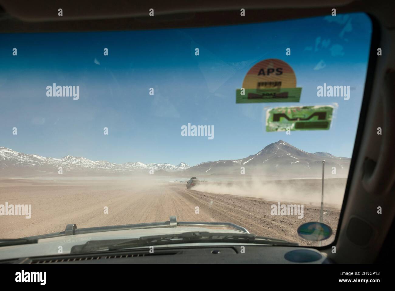 Visto dal sedile del passeggero anteriore, un veicolo 4x4 guida lungo una pista desertica boliviana in un safari turistico terrestre Foto Stock