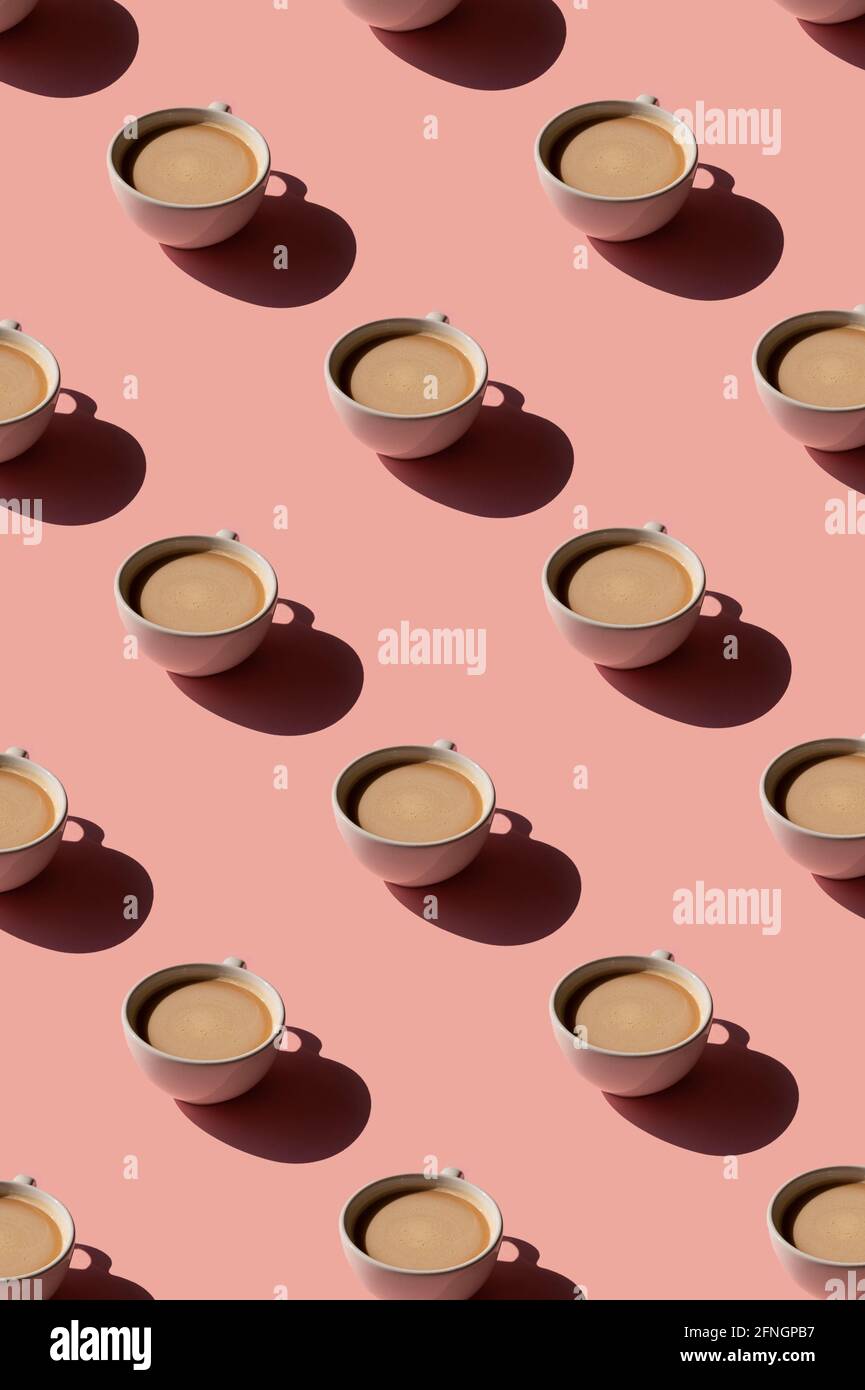 Tazza di caffè su sfondo rosa. Concetto di tendenza alla luce del sole minimale Foto Stock