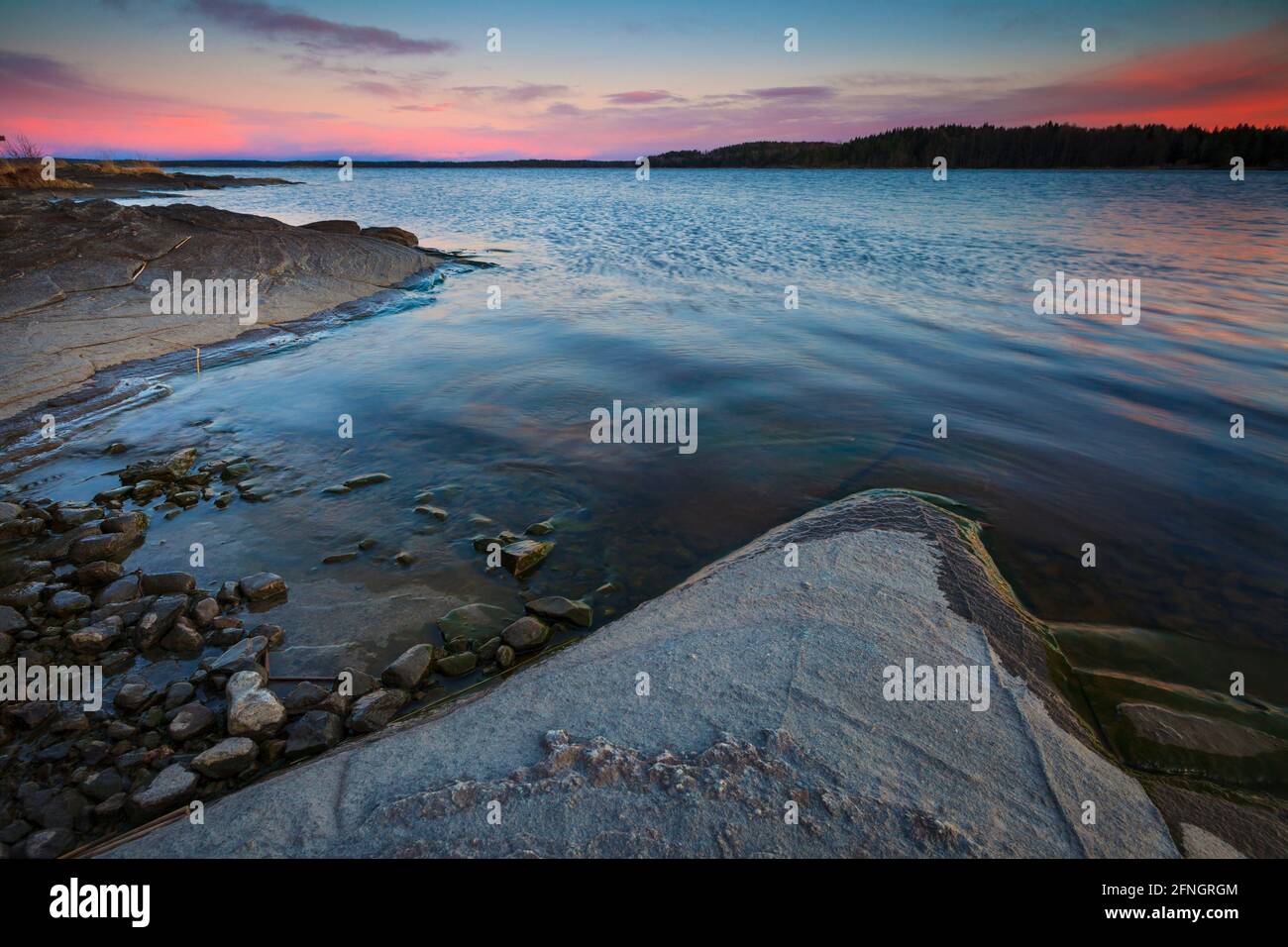 Colorata e bella serata di primavera sul lago roccioso del lago Vansjø, Østfold, Norvegia, Scandinavia. Foto Stock