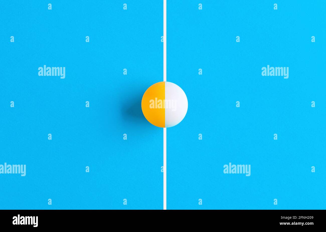 La palla da ping pong si è dimezzata in due colori diversi sulla linea di un tavolo da ping pong. Sfida di squadra e concetto di concorrenza. Foto Stock