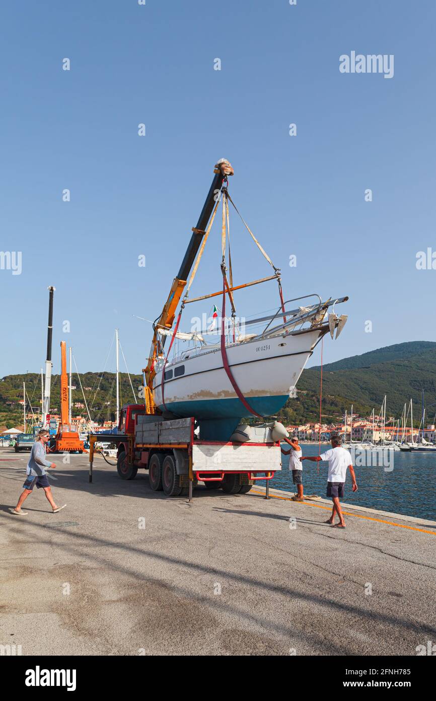 MARCIANA MARINA, ISOLA D'ELBA, ITALIA - 22 GIUGNO 2012: Team di persone che si preparano a lanciare un motoscafo in acqua. Foto Stock