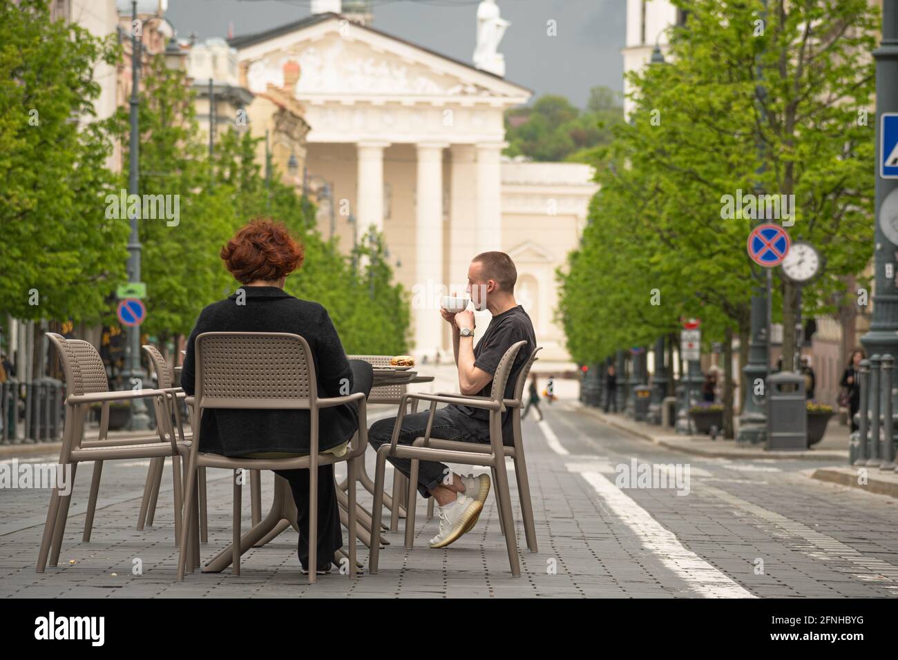 Bar e ristorante all'aperto che si trasformano in una vasta caffetteria all'aperto, riaprendosi dopo il blocco e le restrizioni, tavoli e sedie con i clienti che mangiano Foto Stock