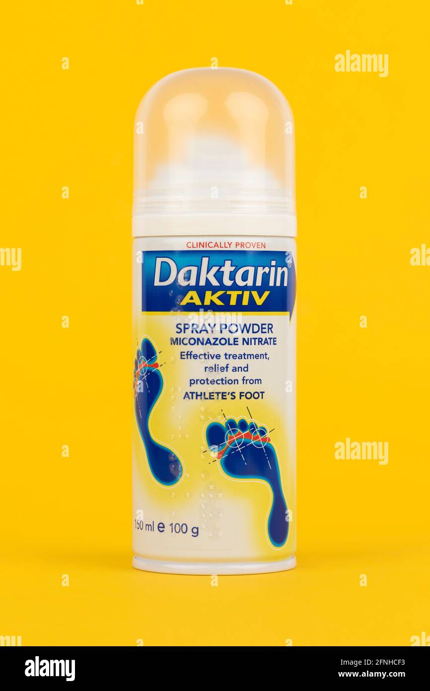Una lattina di Daktarin ACTIV su sfondo giallo. Foto Stock