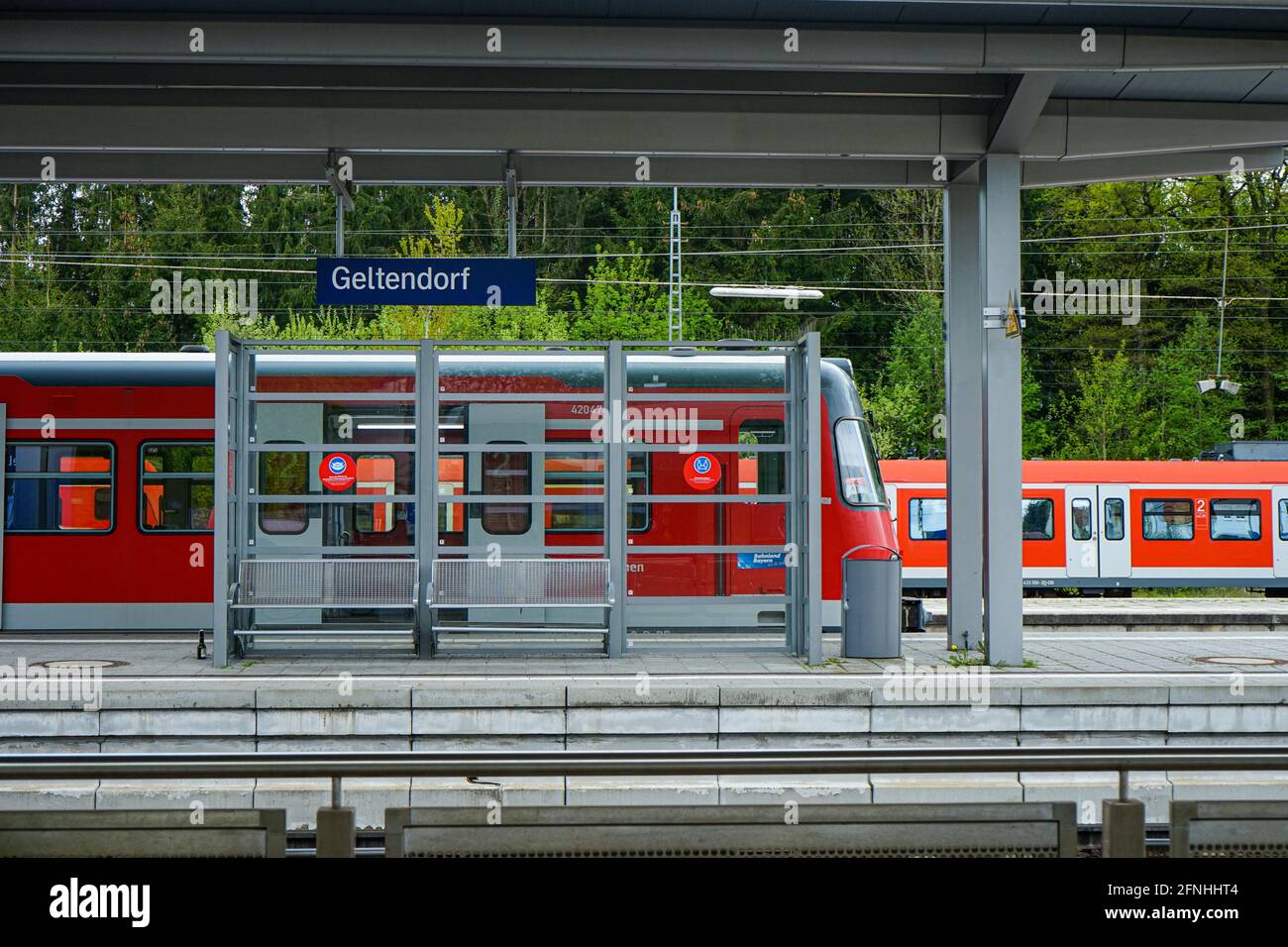 Vista della piattaforma della stazione Geltendorf nel quartiere Fürstenfeldbruck, dove due treni rossi della S-Bahn operati dalla compagnia di trasporti pubblici di Monaco Foto Stock