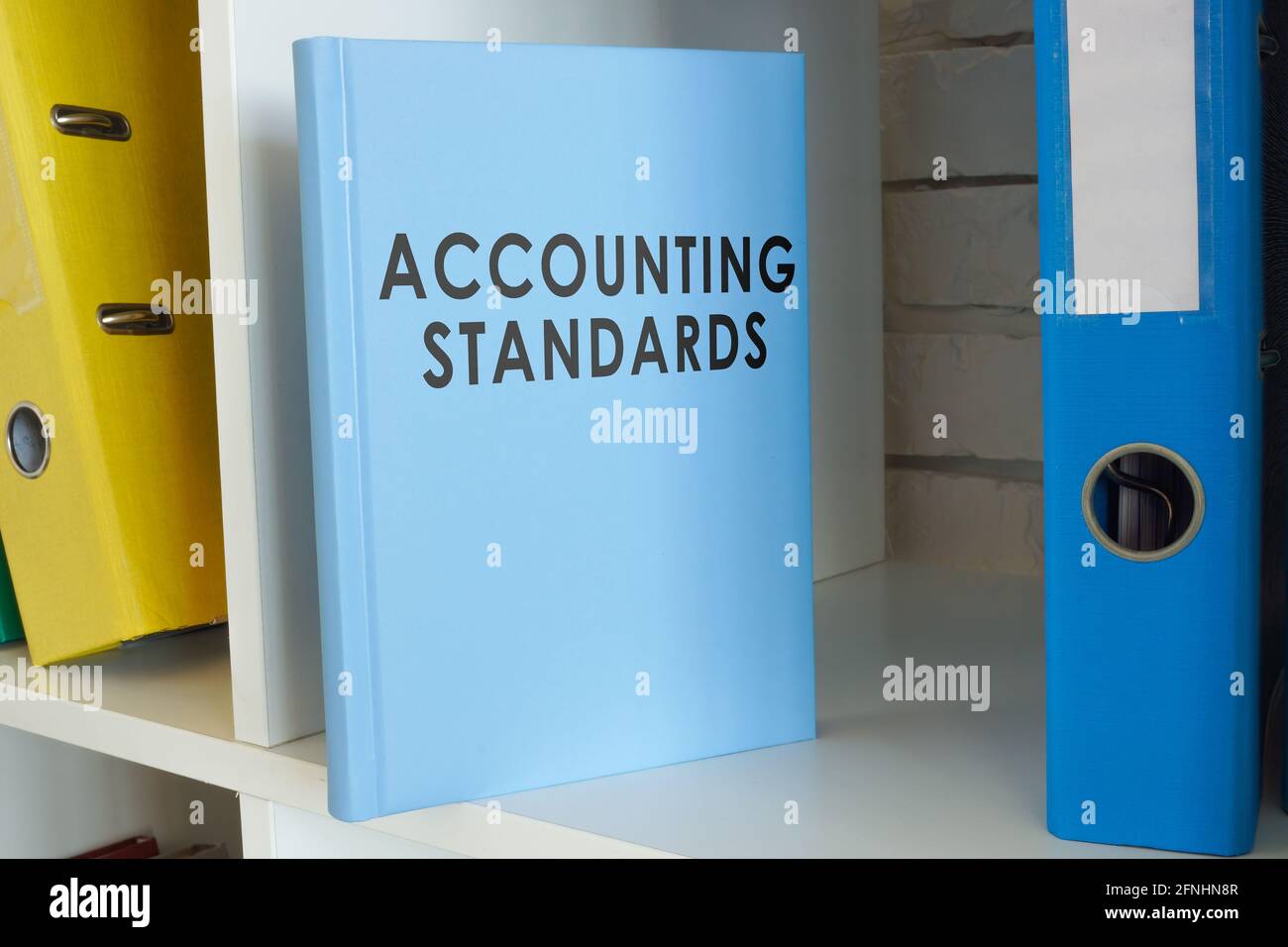 Libro degli standard contabili sullo scaffale con cartelle. Foto Stock