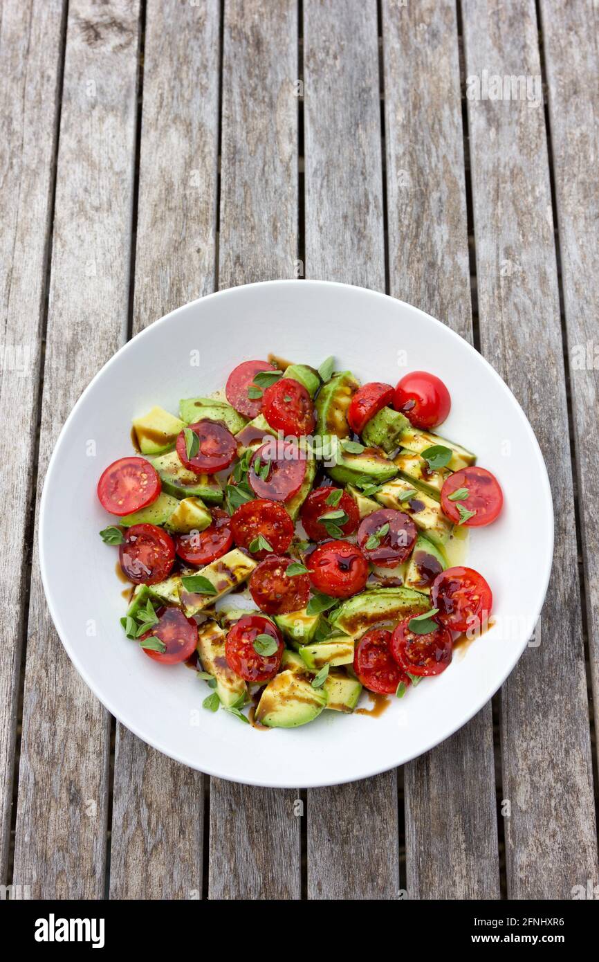 Insalata di pomodoro e avocado con erbe e aceto balsamico. Foto Stock