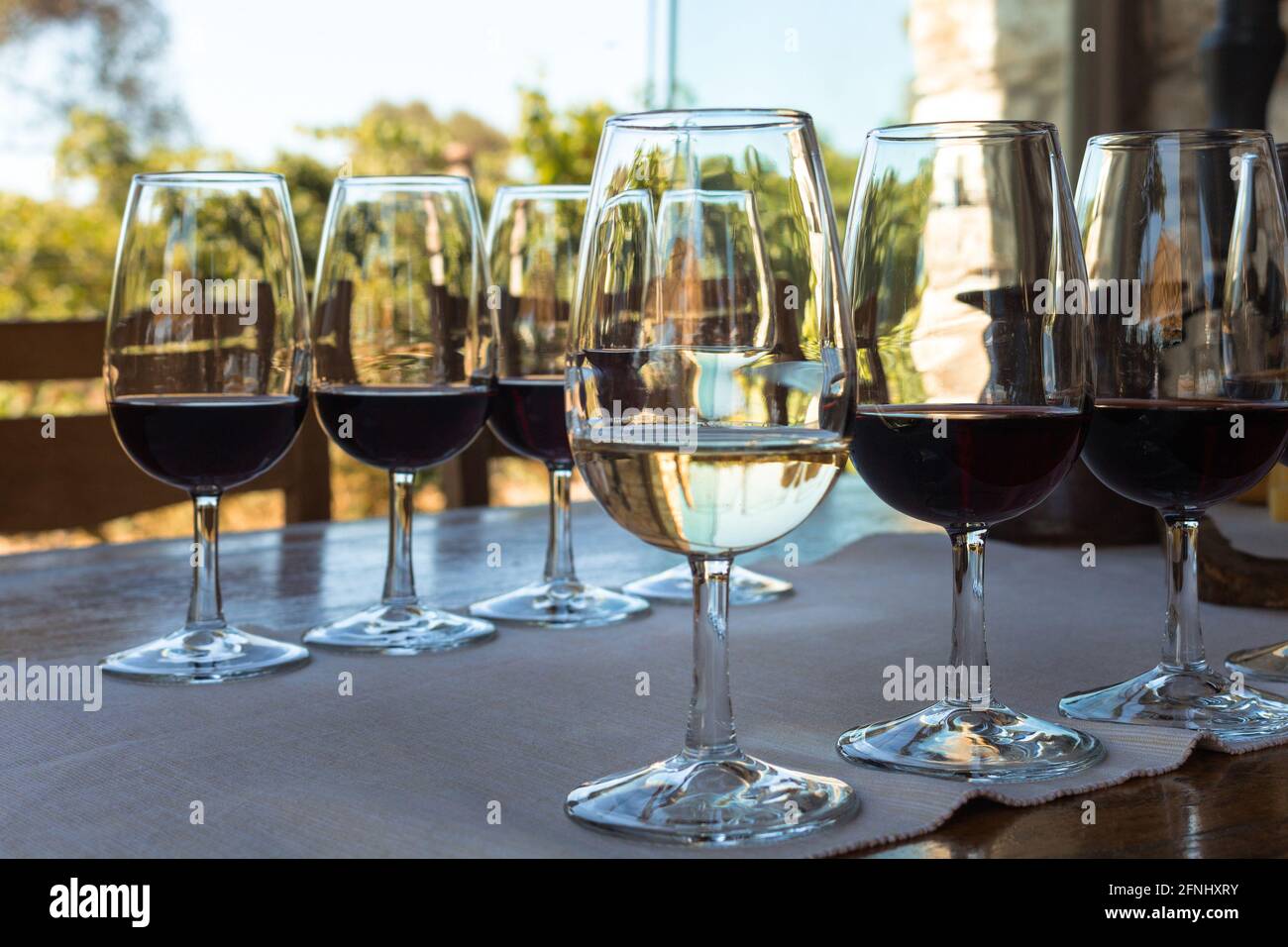Primo piano vista dei bicchieri da vino sul tavolo durante la degustazione di vini nel quartiere di Urla nella provincia di Smirne in Turchia. È una giornata estiva soleggiata. Foto Stock