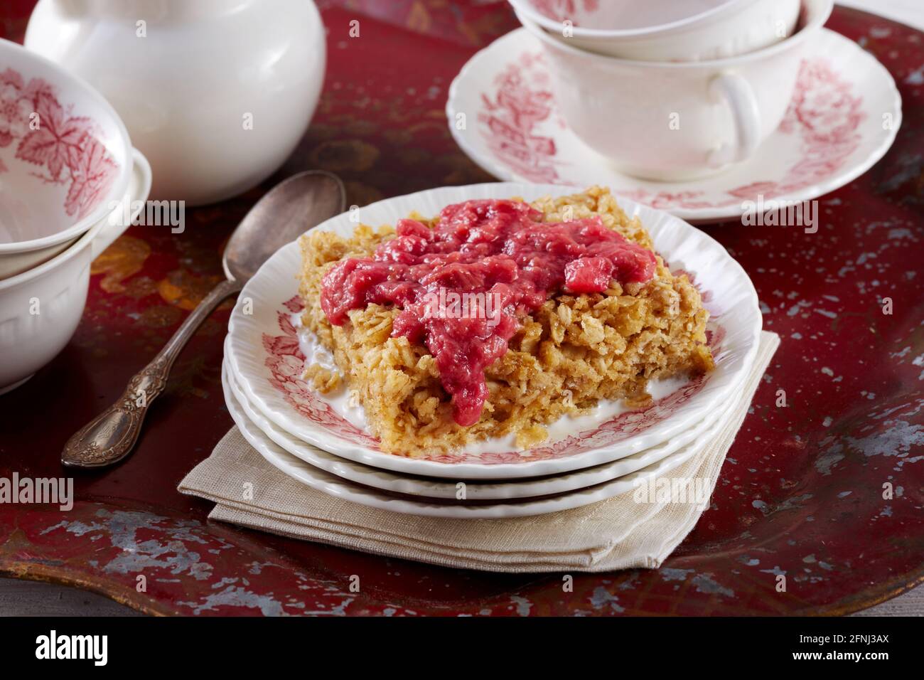 Torta di farinata d'avena con salsa di rabarbaro su vassoio rosso Foto Stock