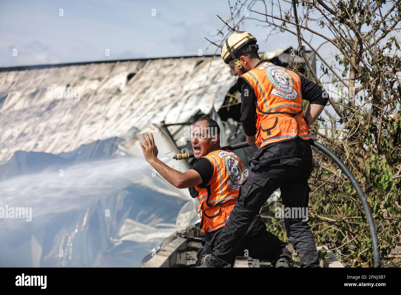 Gaza, Palestina. 16 maggio 2021. Un pompiere palestinese reagisce mentre cerca di estinguere un incendio in una fabbrica di spugne dopo che è stato colpito da gusci d'artiglieria israeliani, secondo i testimoni, nella striscia di Gaza settentrionale. (Foto di Nidal Alwaheidi/SOPA Images/Sipa USA) Credit: Sipa USA/Alamy Live News Foto Stock