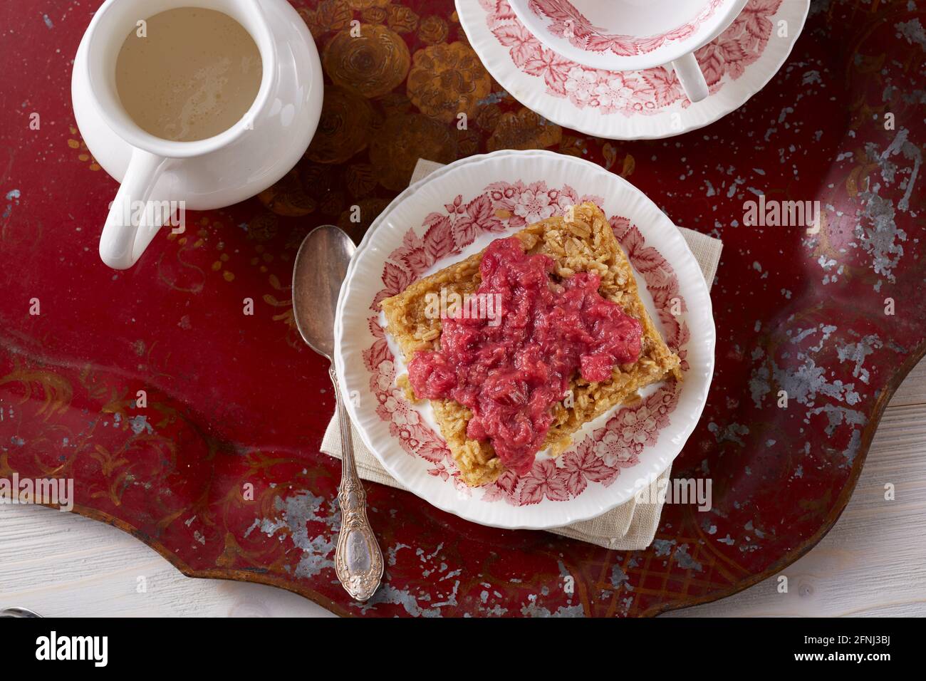 Torta di farinata d'avena con salsa di rabarbaro su vassoio rosso Foto Stock