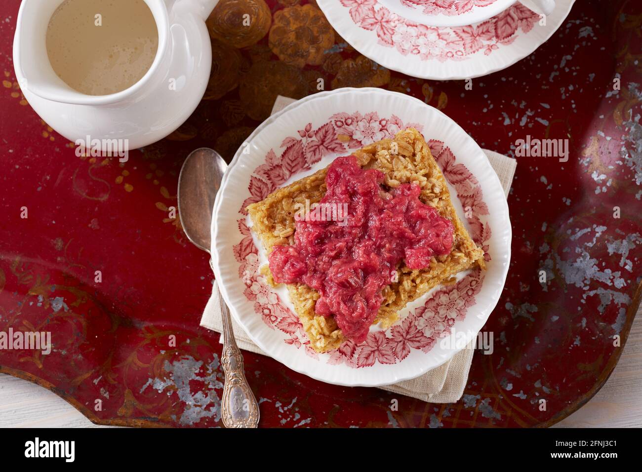 Torta di farinata d'avena con salsa di rabarbaro su vassoio rosso Foto Stock