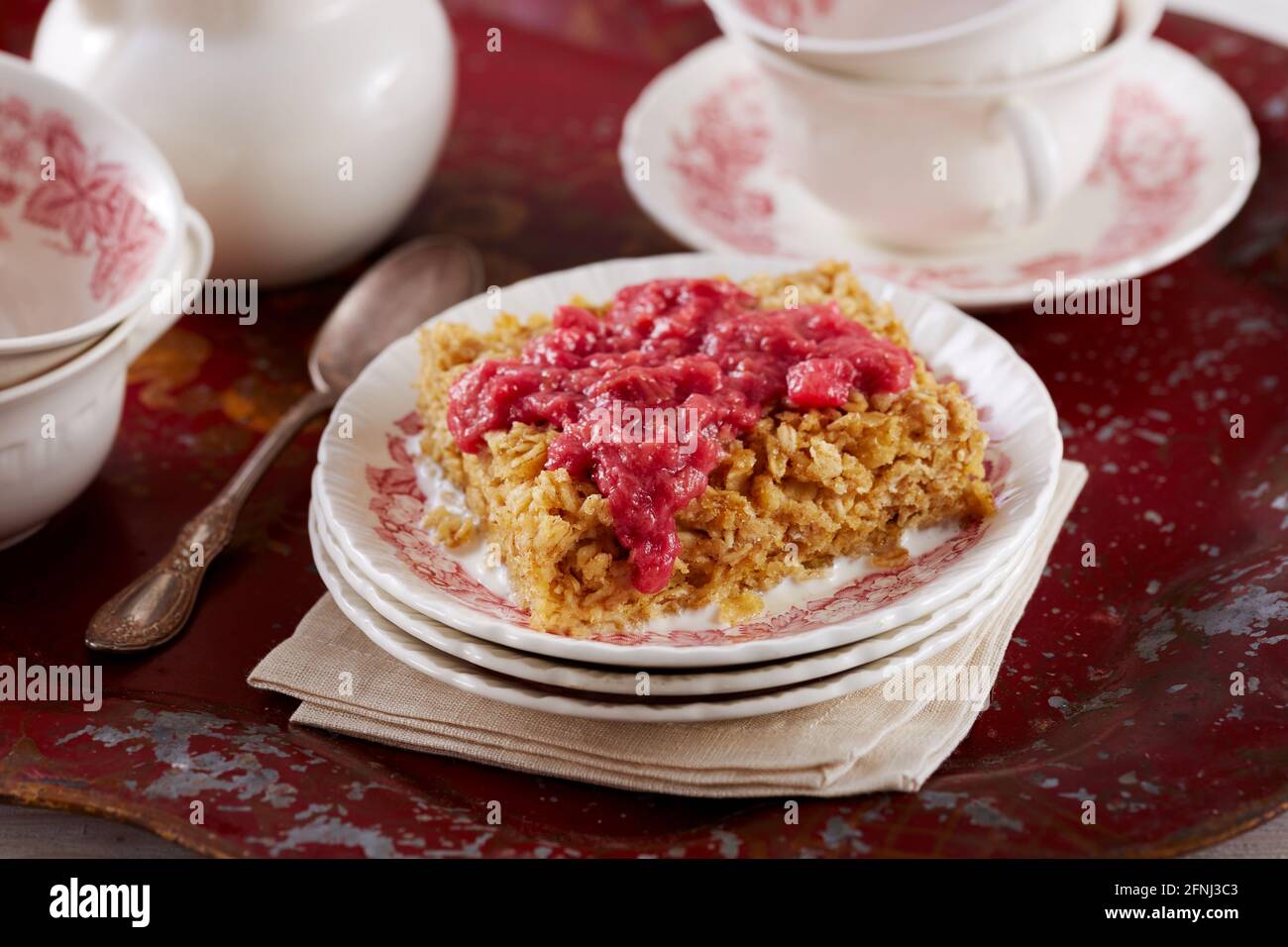 Torta di farinata d'avena con salsa di rabarbaro su vassoio rosso Foto Stock