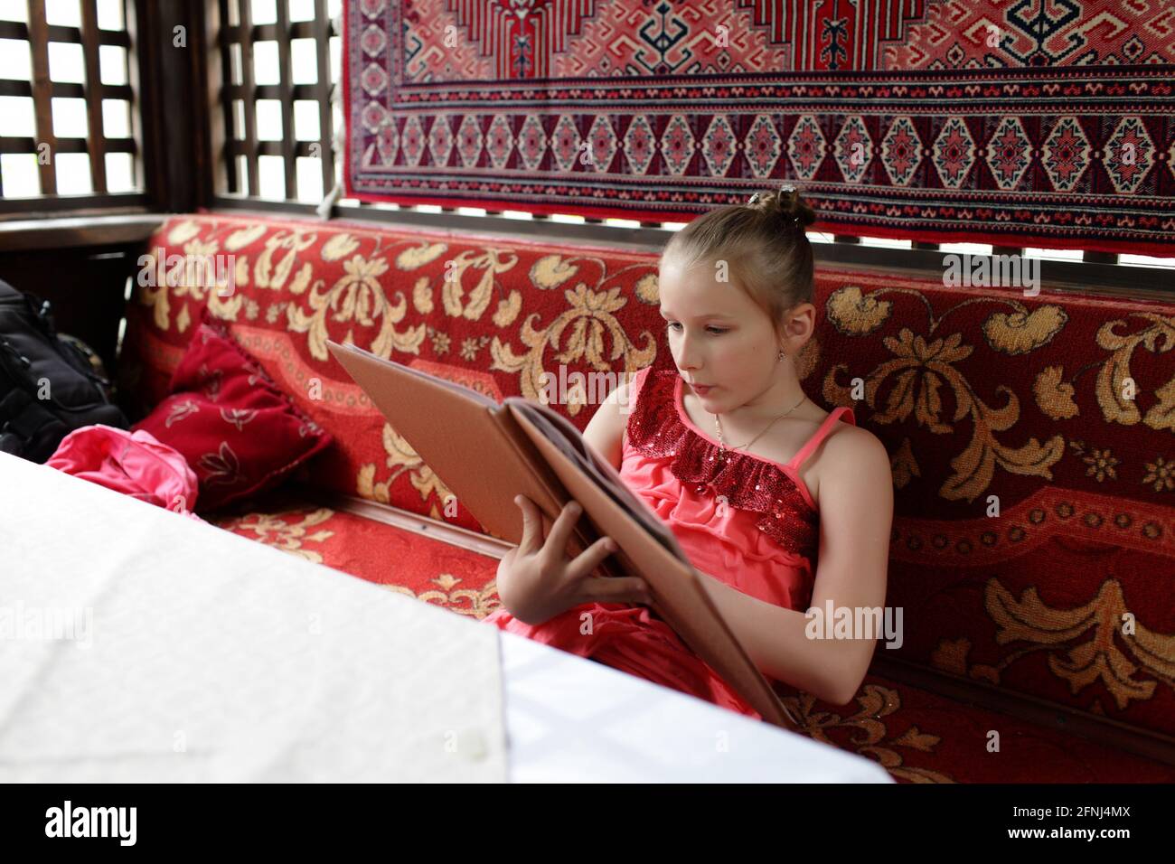 La ragazza sceglie il piatto in un caffè asiatico Foto Stock
