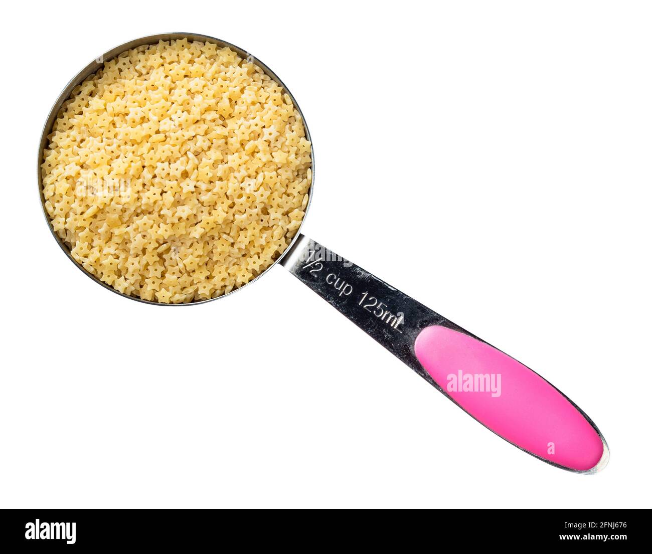 vista dall'alto della pastina stellina non cotte nel foro della tazza di misurazione su sfondo bianco Foto Stock