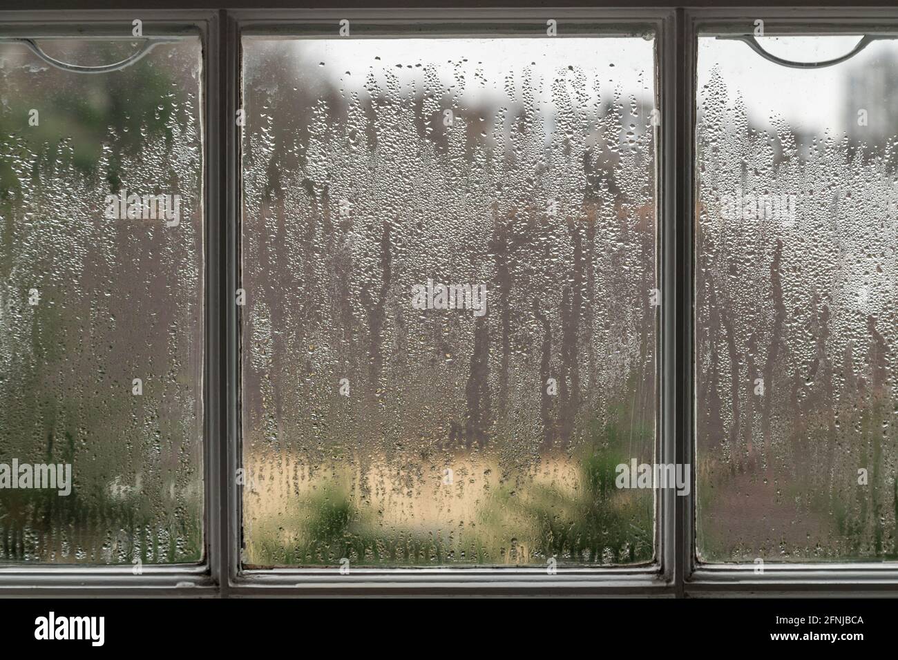 Fare in modo che si formi condensa sul vetro di una finestra. Un problema comune quando i finestrini non sono doppi vetri. Foto Stock
