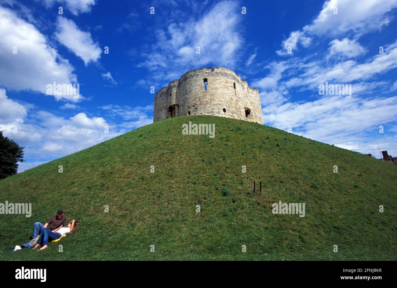 Giovane coppia in prato nel castello medievale normanno, Clifford's Tower, York, Yorkshire e The Humber, Inghilterra, Regno Unito Foto Stock