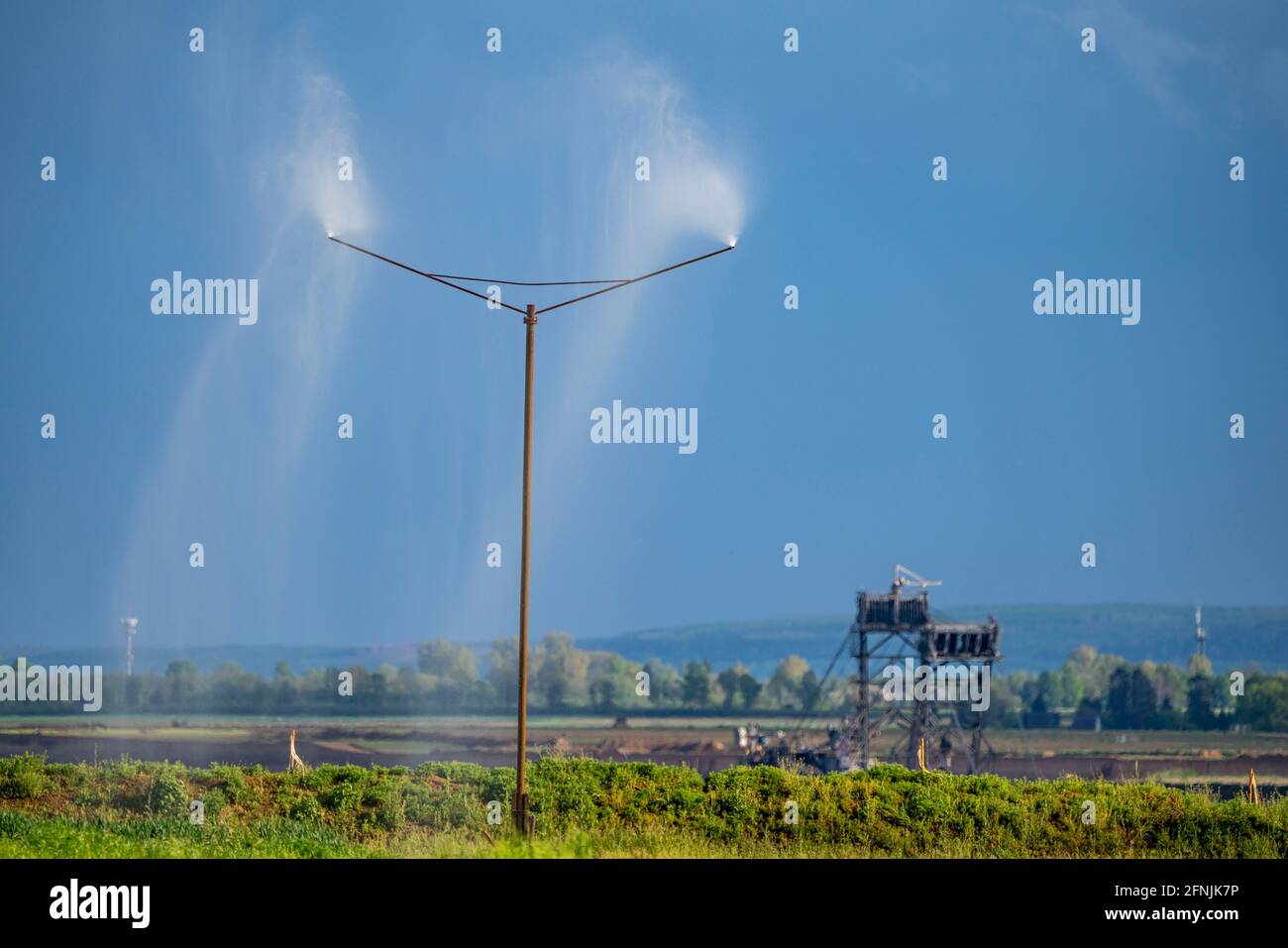 Garzweiler II opencast lignite miniera, l'acqua viene spruzzata sul bordo della miniera per legare la polvere dalla miniera, centrali eoliche, Jüchen, NRW, Germania Foto Stock