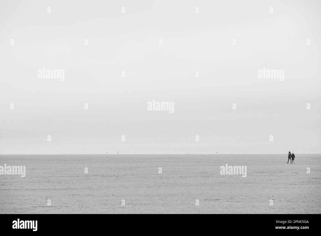 Due turisti camminano lungo la spiaggia di Sankt Peter Ording Foto Stock
