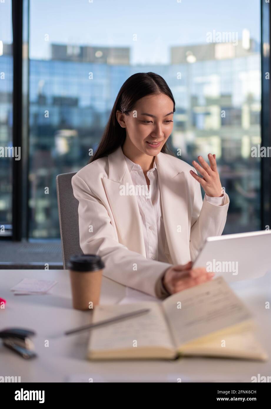 Donna asiatica che discute di lavoro con la collega online Foto Stock