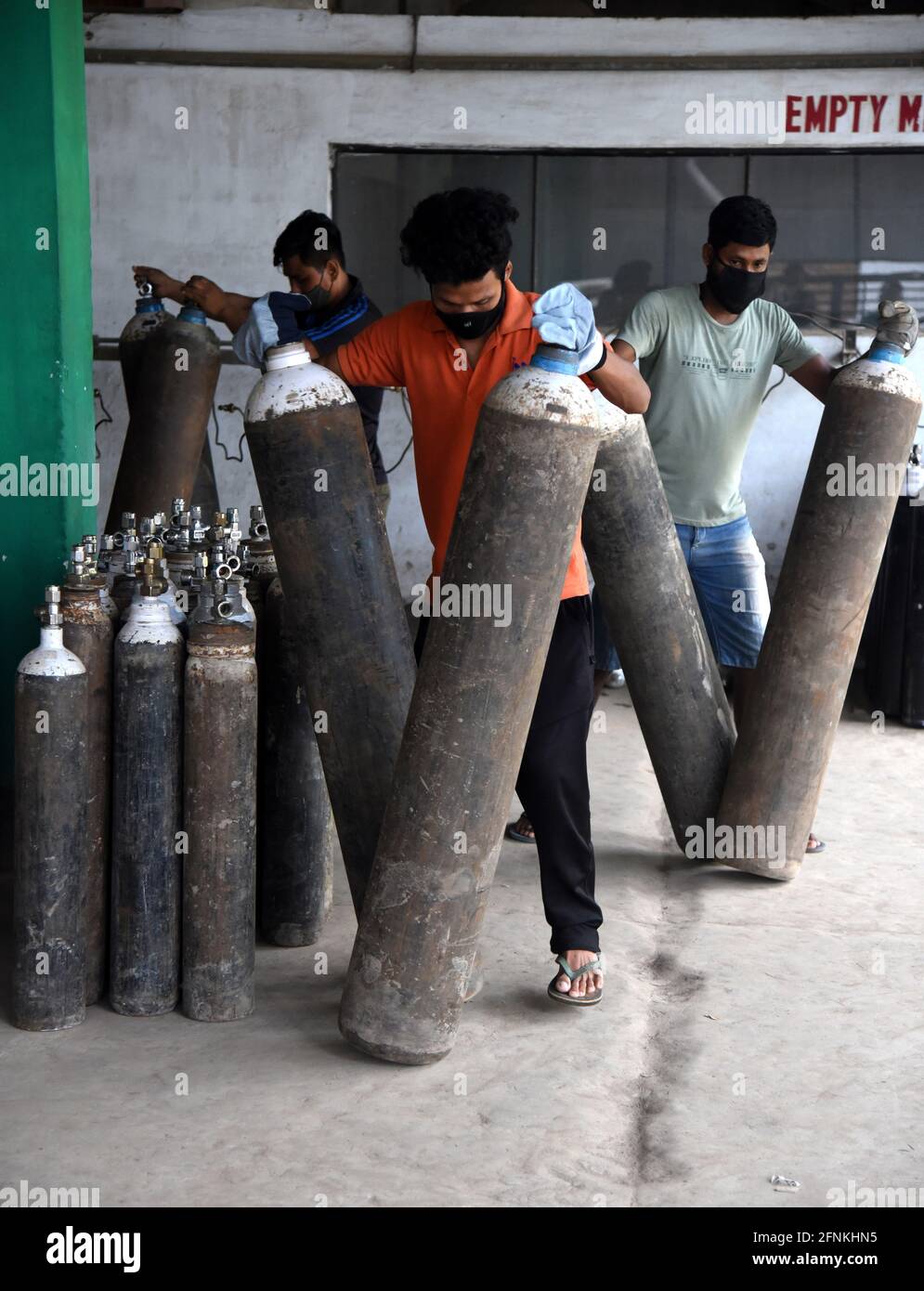 Guwahati, Assam, India. 17 maggio 2021. Lavoratori che tengono le bombole di gas ossigeno in modo sistematico nella stazione di riempimento di gas ossigeno durante l'aumento in COVID-19 nello stato in Guwahati Assam India martedì 17 maggio 2021. Credit: Dasarath Deka/ZUMA Wire/Alamy Live News Foto Stock