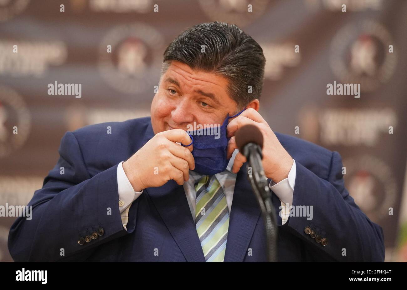 East St. Louis, Stati Uniti. 17 maggio 2021. Il Governatore dell'Illinois JB Pritzker rimuove la sua maschera facciale prima di una conferenza stampa per annunciare che le richieste per il secondo round di finanziamento per l'assistenza a noleggio sono ora disponibili per aiutare i residenti dell'Illinois che hanno sperimentato difficoltà economiche a causa della pandemia, a East St. Louis Illinois lunedì 17 maggio 2021. L'Illinois Rental Payment Program finanzierà 1.1 miliardi di dollari ai noleggiatori e proprietari dell'Illinois nel tentativo di prevenire gli sfratti. Photo by Bill Greenblatt/UPI Credit: UPI/Alamy Live News Foto Stock