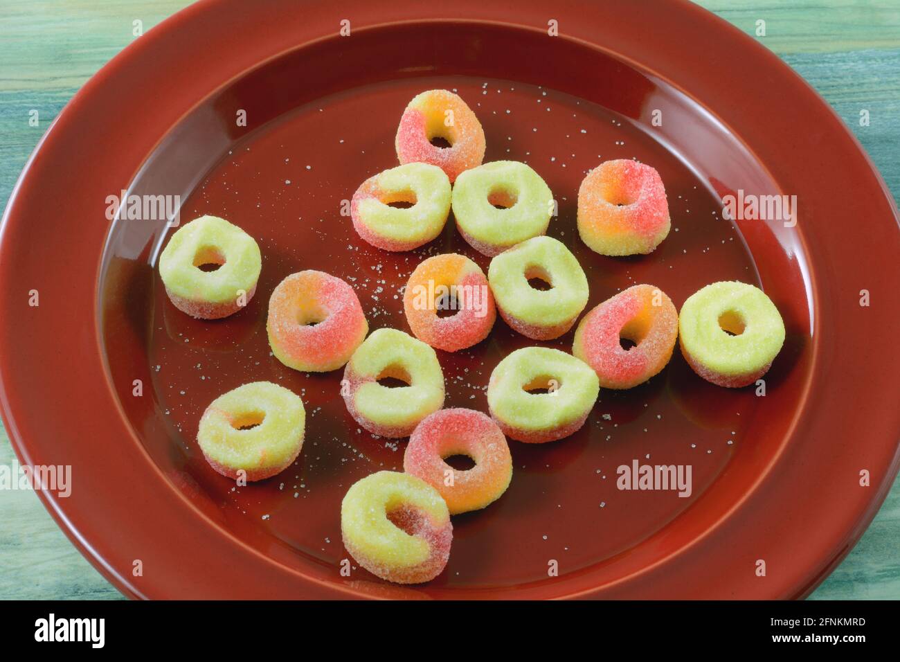 Spuntino caramella gommosa con zucchero su dessert rosso piastra Foto Stock