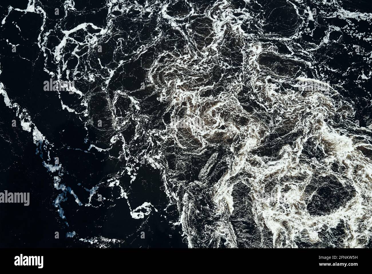 Onde d'acqua nel fiume con idromassaggio, vista aerea. Sfondo dell'acqua. Modello astratto delle onde dell'acqua Foto Stock