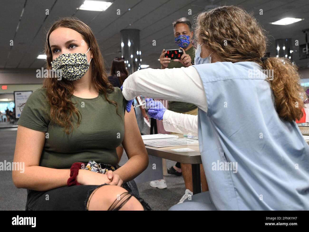 Melbourne, Stati Uniti. 17 maggio 2021. Un'infermiera dà a Sherri Trimble, 15 anni, una dose del vaccino in una clinica di vaccinazione presso il Health First Medical Center. Il 12 maggio 2021, il CDC ha approvato l'uso del vaccino Pfizer BioNTech in 15 adolescenti di 12 anni. La vaccinazione di questa fascia di età è vista come una chiave per la piena riapertura delle scuole medie e superiori entro l'autunno. Credit: SOPA Images Limited/Alamy Live News Foto Stock