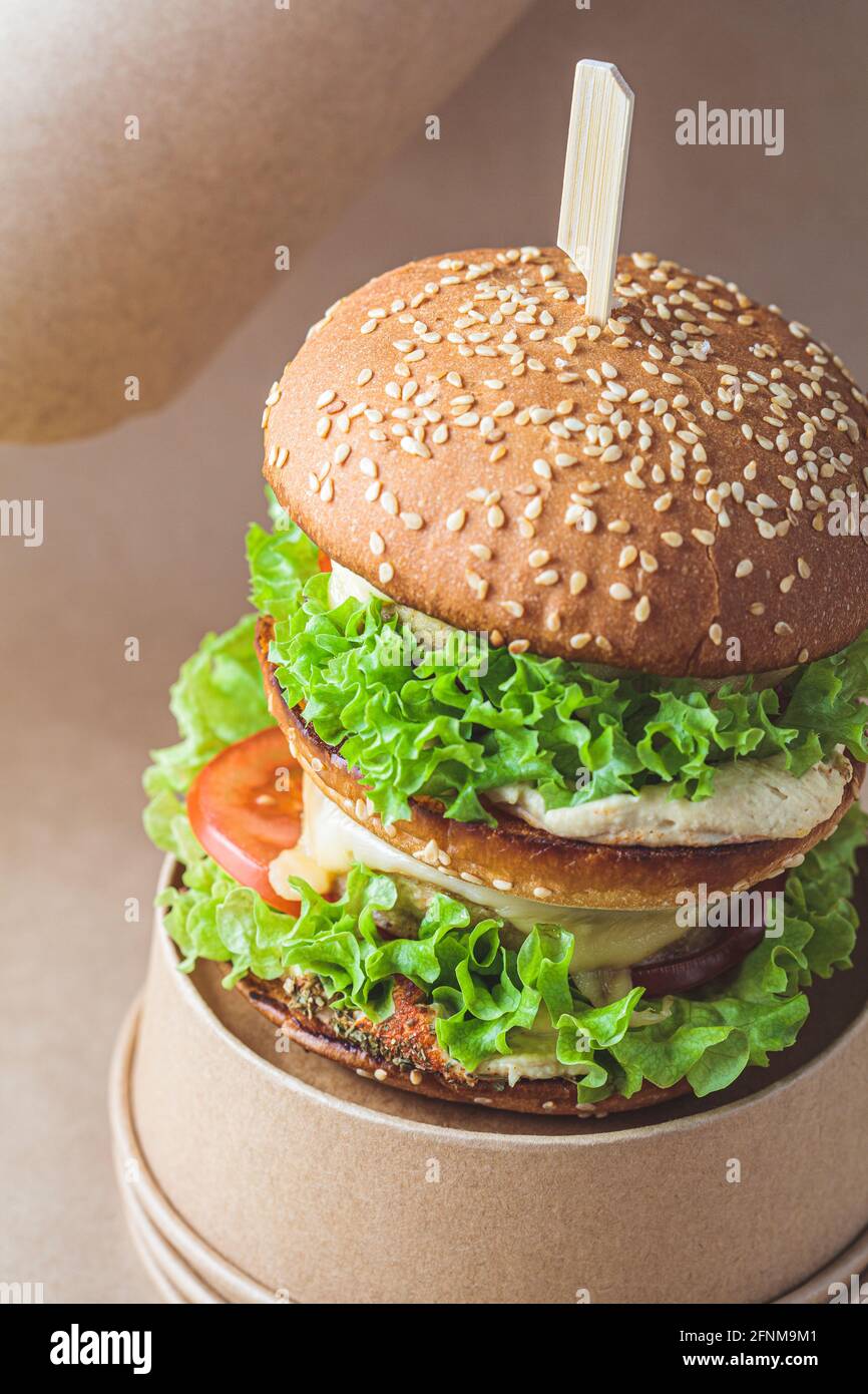 Hamburger vegano con verdure e hummus, fondo kraft marrone. Riciclaggio degli imballaggi alimentari, concetto zero rifiuti. Concetto di dieta a base di piante. Foto Stock