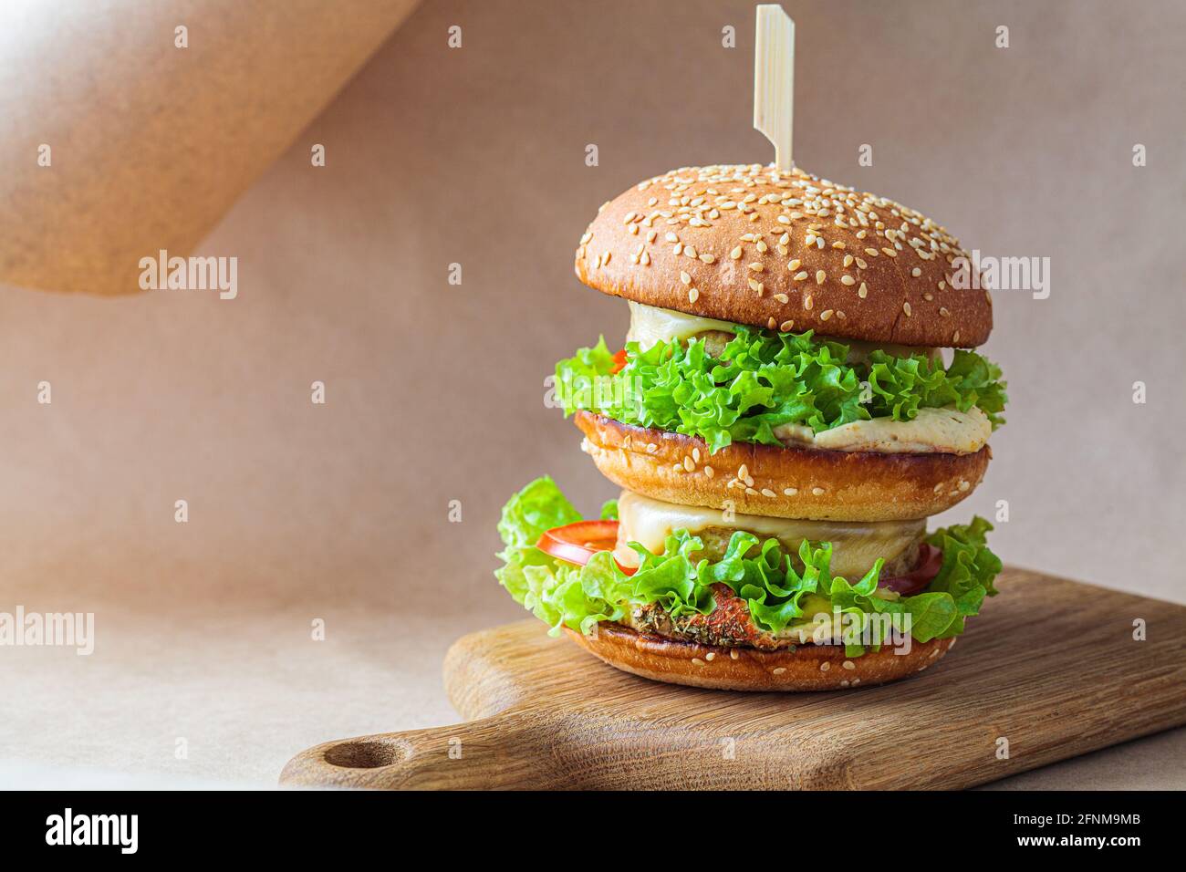 Hamburger vegano con verdure e hummus, fondo kraft marrone. Riciclaggio degli imballaggi alimentari, concetto zero rifiuti. Concetto di dieta a base di piante. Foto Stock