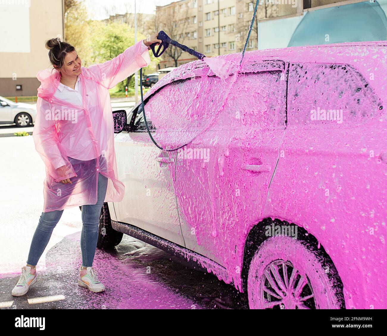 auto in schiuma rosa al lavaggio auto, donna si lava felicemente la sua auto  Foto stock - Alamy