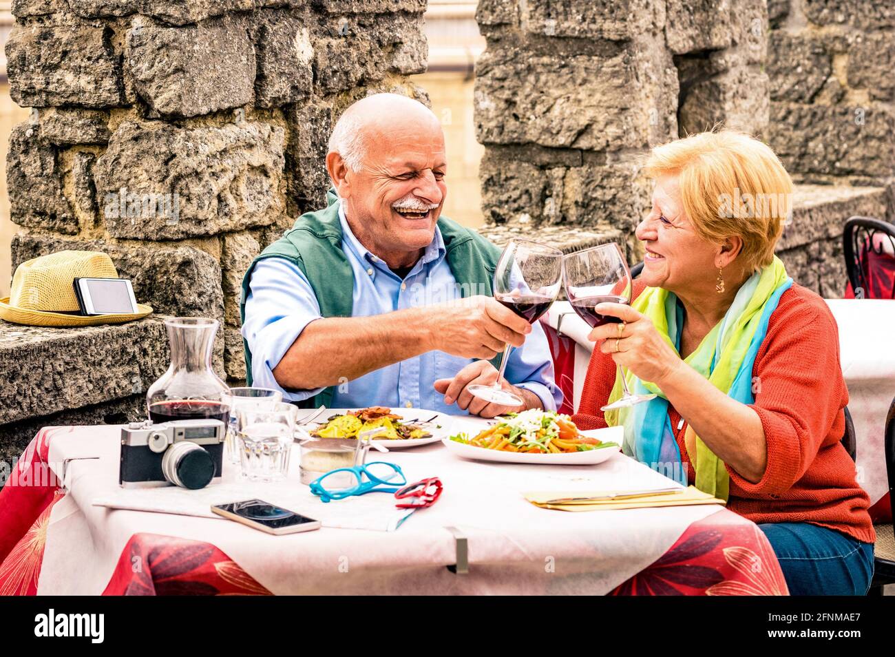 Coppia senior che si diverte e mangia al ristorante durante il viaggio - uomo maturo e moglie donna nella città vecchia bar durante le vacanze attive per anziani Foto Stock