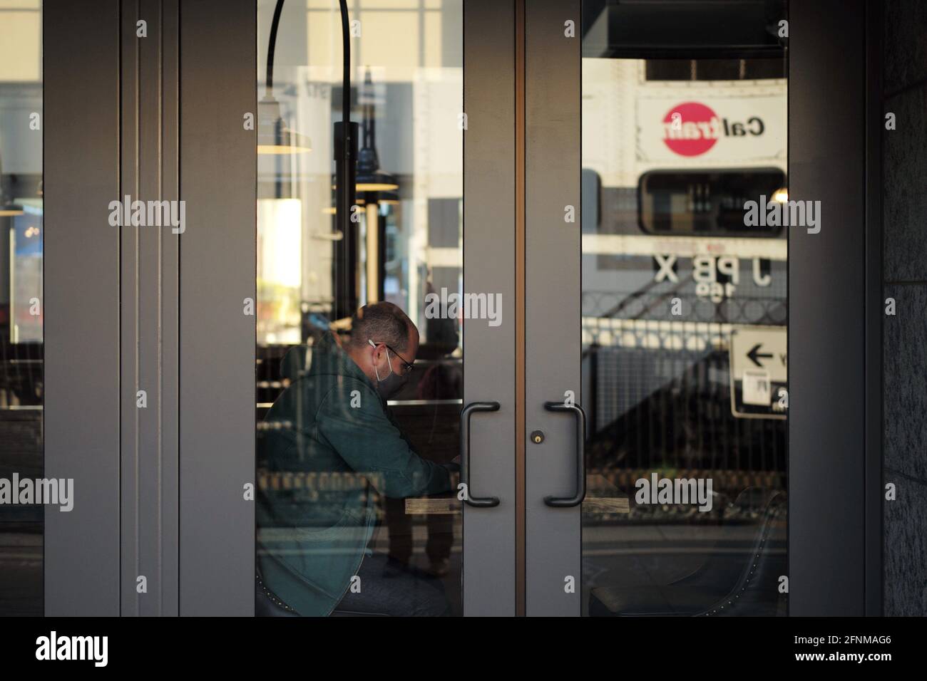 (210518) -- SAN MATEO, 18 maggio 2021 (Xinhua) -- UN cliente che indossa una maschera ordina il cibo in un ristorante a San Mateo, California, Stati Uniti, 17 maggio 2021. I funzionari di sanità pubblica della California hanno detto lunedì lo stato più popoloso degli Stati Uniti non 'applicherebbe le linee guida di CDC che permettono alle persone completamente vaccinate di andare senza una maschera nella maggior parte delle situazioni' prima di giugno 15. La scorsa settimana, i Centri statunitensi per il controllo e la prevenzione delle malattie (CDC) hanno dichiarato che è sicuro per le persone completamente vaccinate di saltare i rivestimenti facciali e le distanze sociali nella maggior parte delle situazioni, e molti stati hanno sollevato il loro Foto Stock