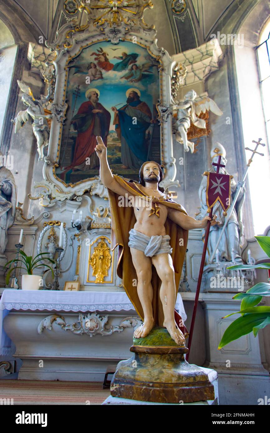 Statua di Gesù risurrezione con la bandiera a croce maltese all'interno della chiesa di fronte all'altare con dipinto di San Pietro e Paolo. Foto Stock