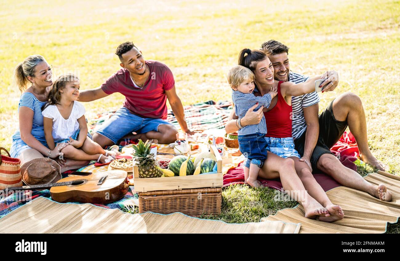 Felici famiglie multirazziali che prendono selfie al pic nic Garden party - concetto multiculturale di gioia e amore con la gente mista di razza divertirsi insieme Foto Stock