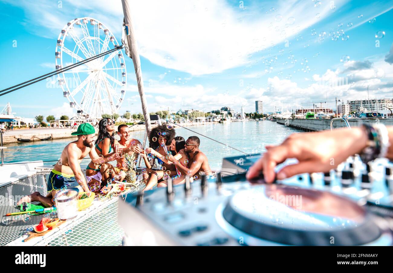 Amici milleniali che si divertono a tostare del vino durante la festa in barca a vela - concetto di viaggio Wanderlust con persone multirazziali in barca a vela - stile di vita di lusso Foto Stock