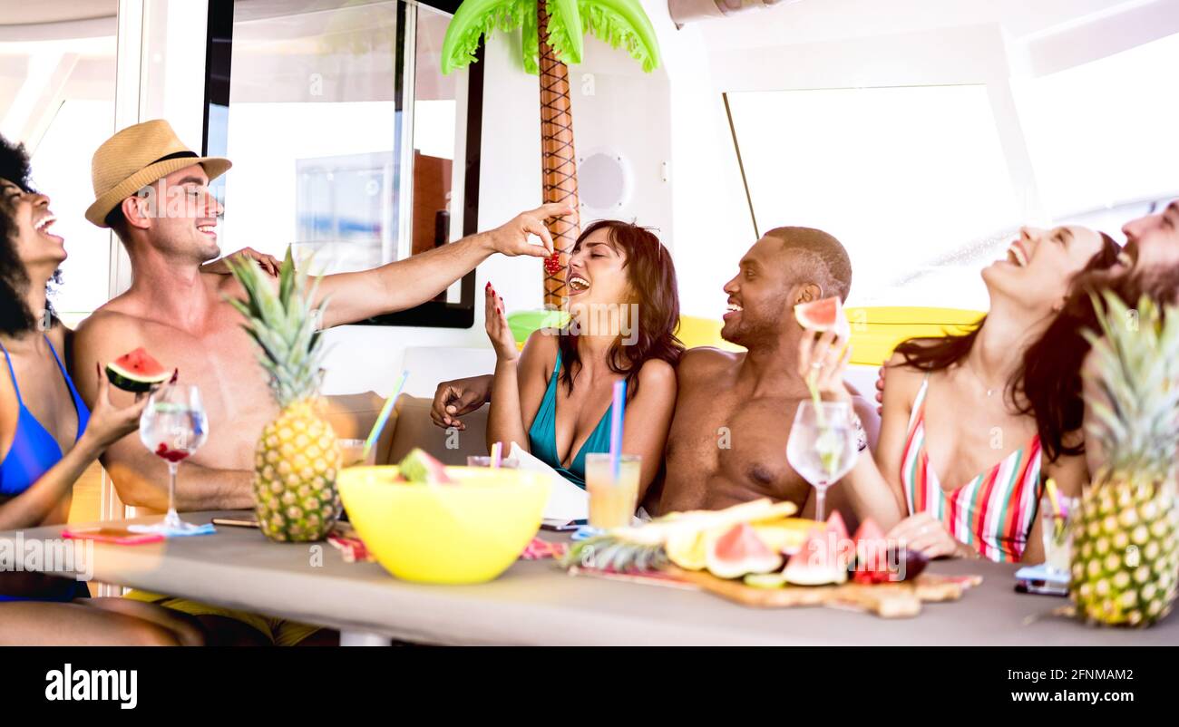 Amici felici che bevono cocktail tropicali alla festa in barca - Young Gente millenaria che si diverte in vacanza di lusso - vita di viaggio concetto di stile Foto Stock