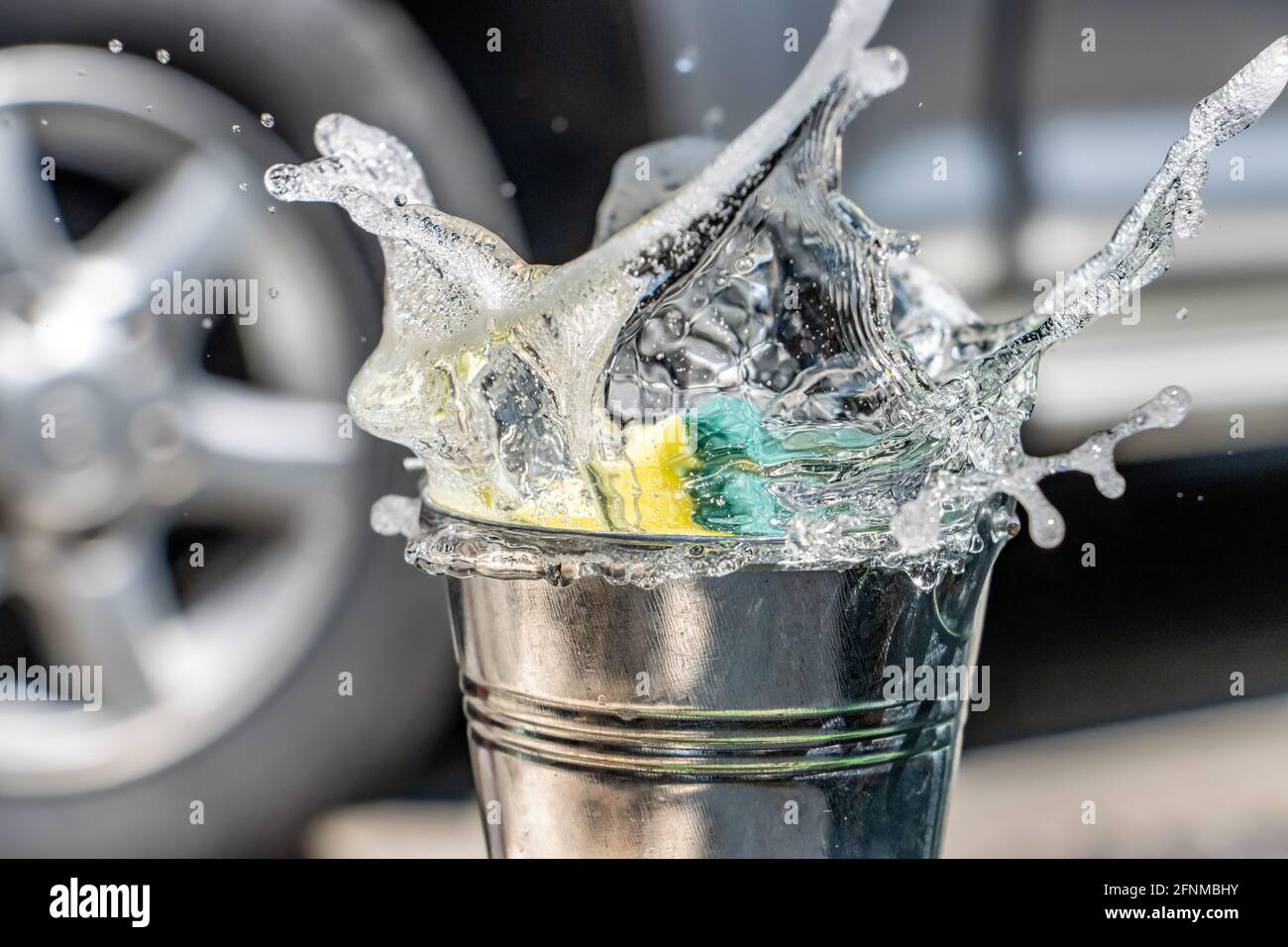 Una spugna cade nel secchio con un po' di detergente. Lavarsi a mano con acqua saponata. Foto Stock
