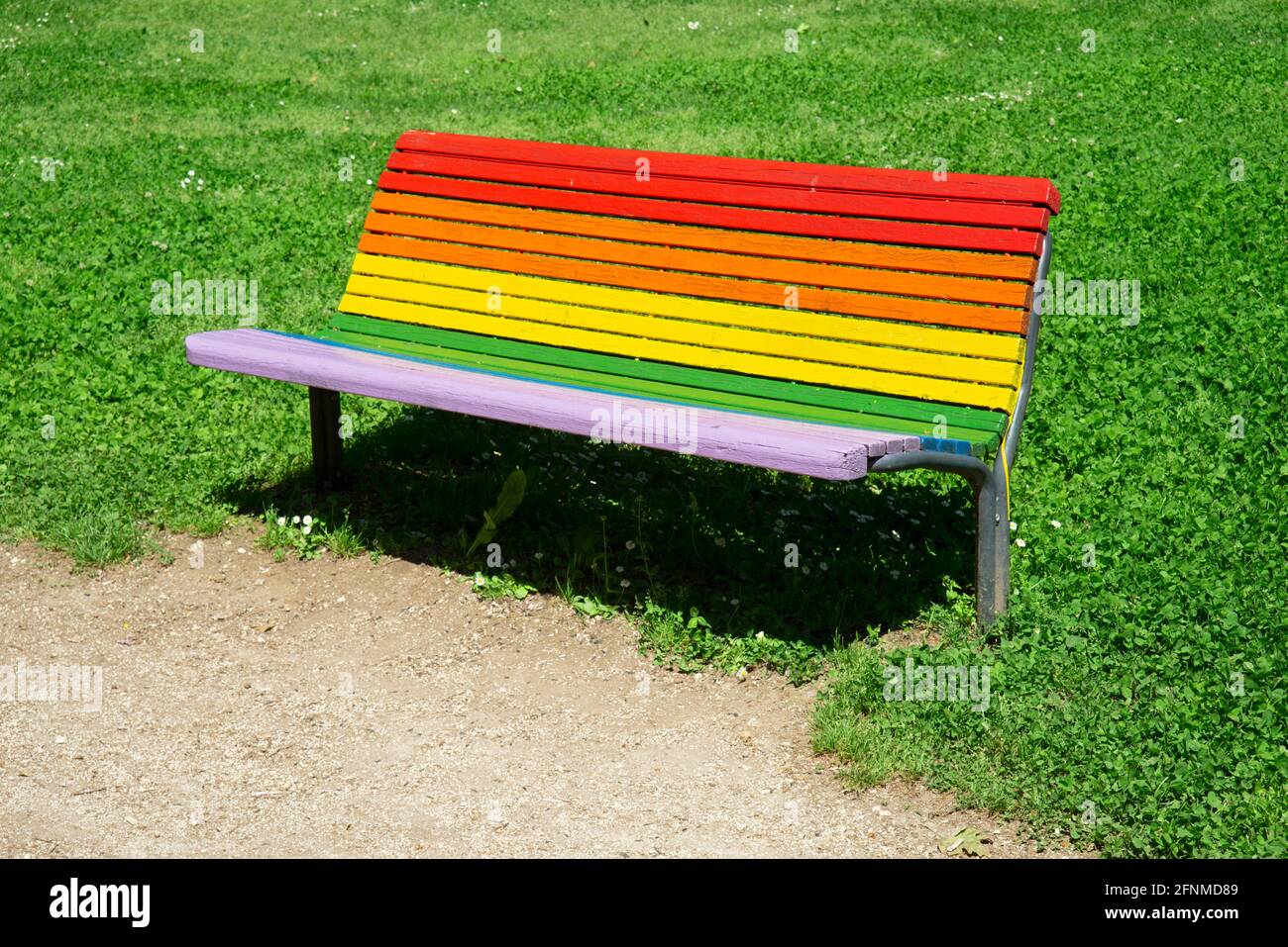Panchina dipinta in colori arcobaleno nel Parco Foto Stock