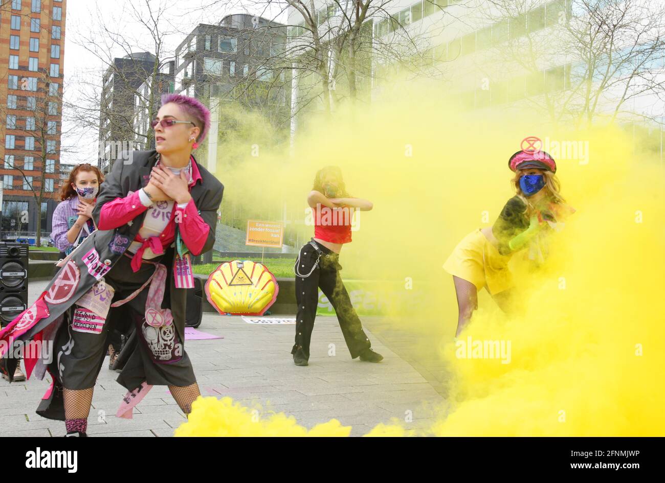 Gli attivisti ambientali olandesi si esibisce con una protesta di fumo giallo contro Shell durante l'assemblea annuale degli azionisti alla Gustav Mahlerplein, nel distretto finanziario di Zuidas, il 18 maggio 2021 ad Amsterdam, Paesi Bassi. I manifestanti ambientali di Greenpeace, Extinction Rebellion, Fossielvrij NL e Code Rood fanno una dimostrazione contro la lobby di Shell, la loro influenza sugli azionisti, e queste conseguenze e chiedono a un'assemblea dei cittadini una politica climatica giusta e incoraggiano ad investire nel verde. (Foto di Paulo Amorim/Sipa USA) Foto Stock