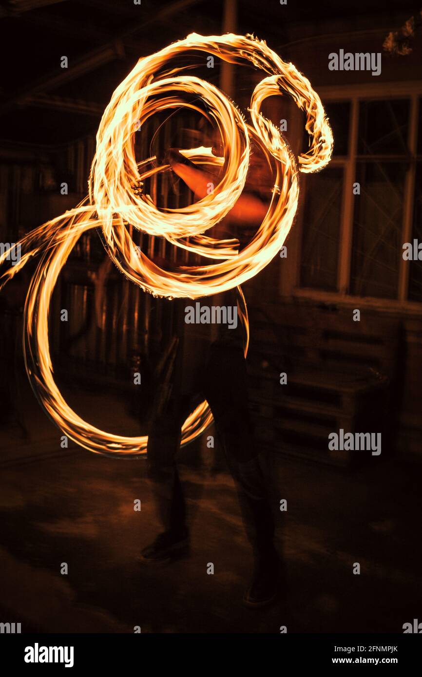 Scatto verticale di un mago che esegue trucchi con il fuoco Foto Stock