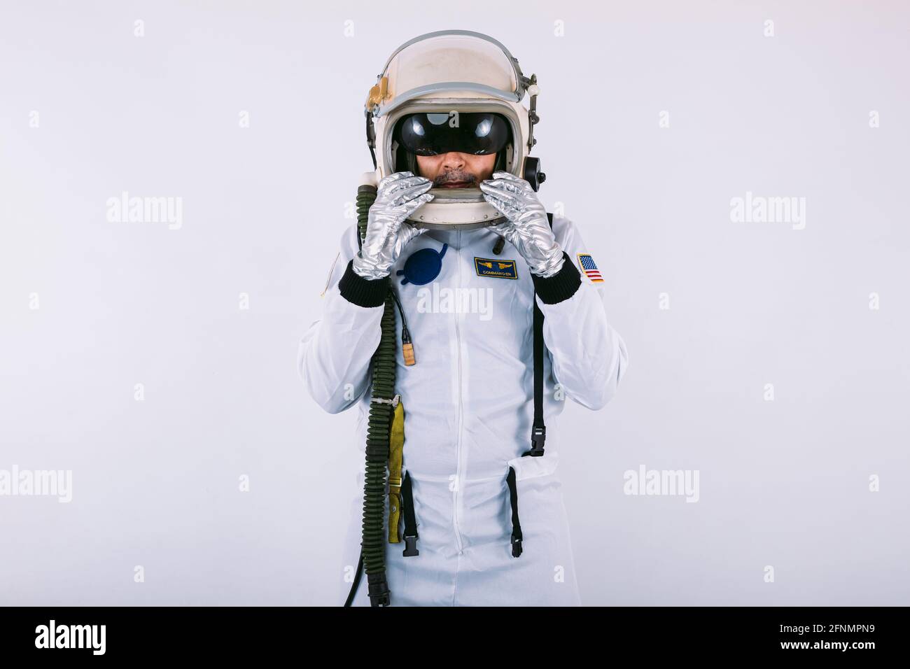 Cosmonauta maschile in spacesuit e casco, tenendo il casco con le mani.  Indossare occhiali di protezione integrati su sfondo bianco Foto stock -  Alamy