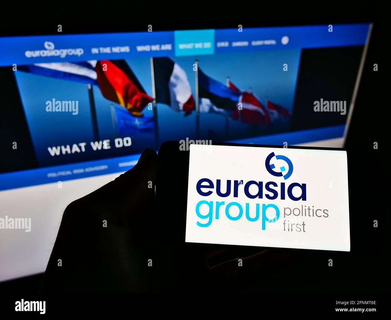 Persona che detiene smartphone con il logo della società di consulenza americana Eurasia Group Ltd sullo schermo di fronte al sito web aziendale. Mettere a fuoco il display del telefono. Foto Stock